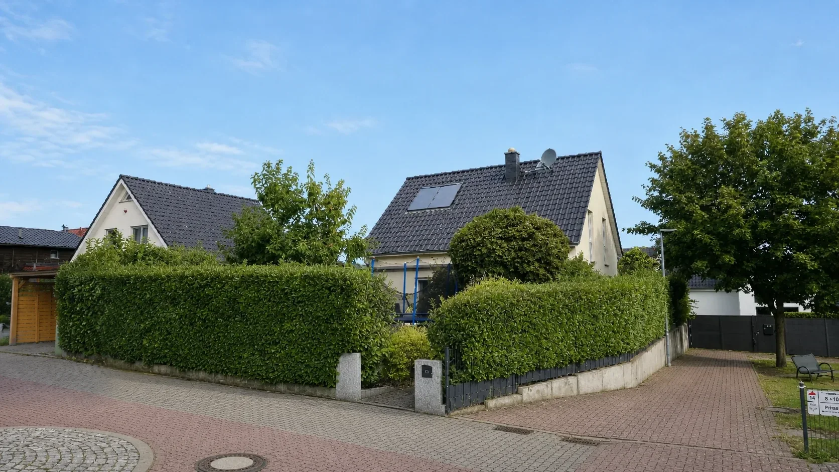 Außenansicht des Einfamilienhauses mit Vorgarten und Zufahrt